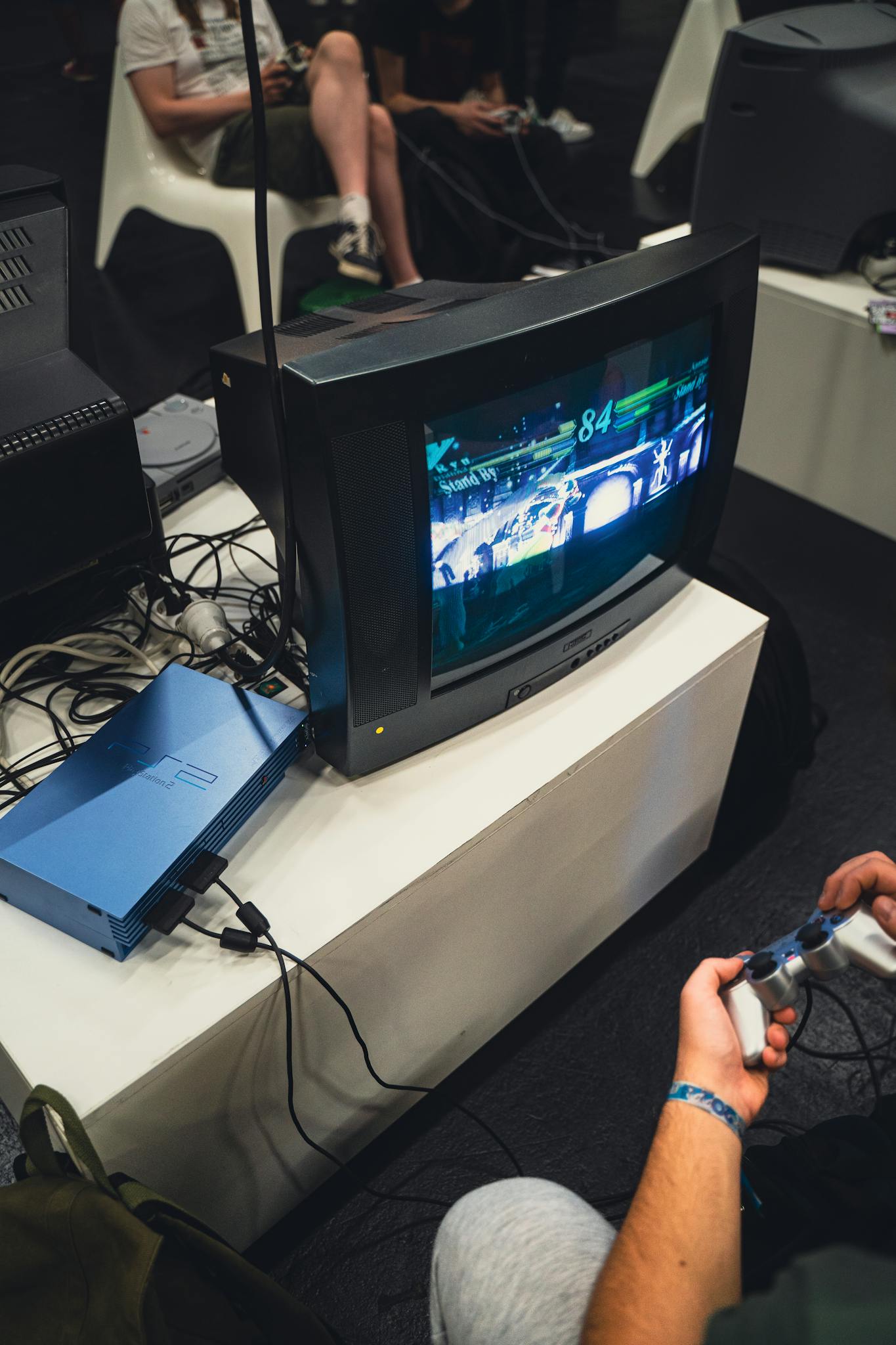 Vintage gaming session featuring PlayStation console and CRT TV with gamers.